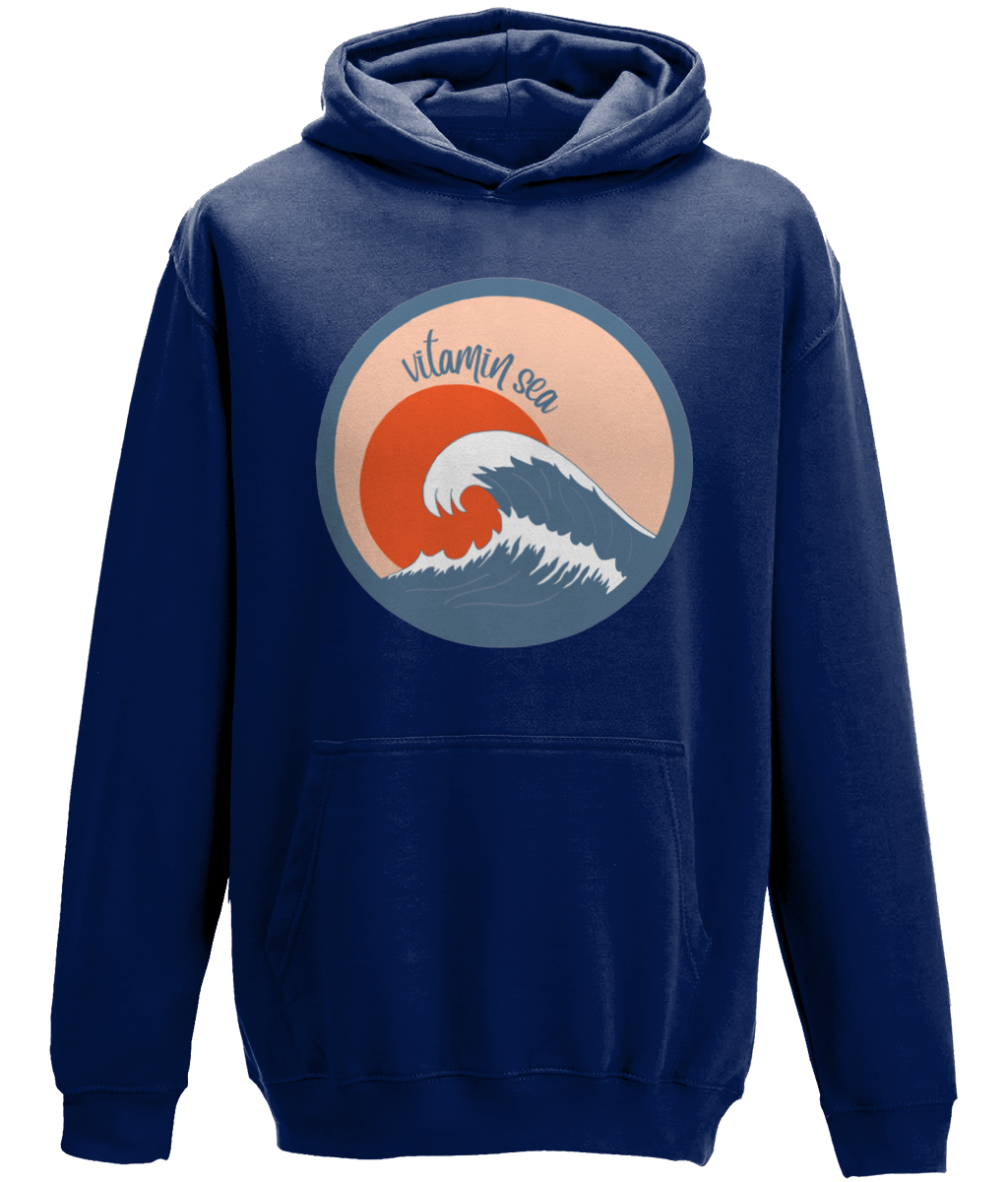 A photo of a Oxford navy kids hoodie with a round Vitamin Sea design featuring a large wave in front of a low orange sun