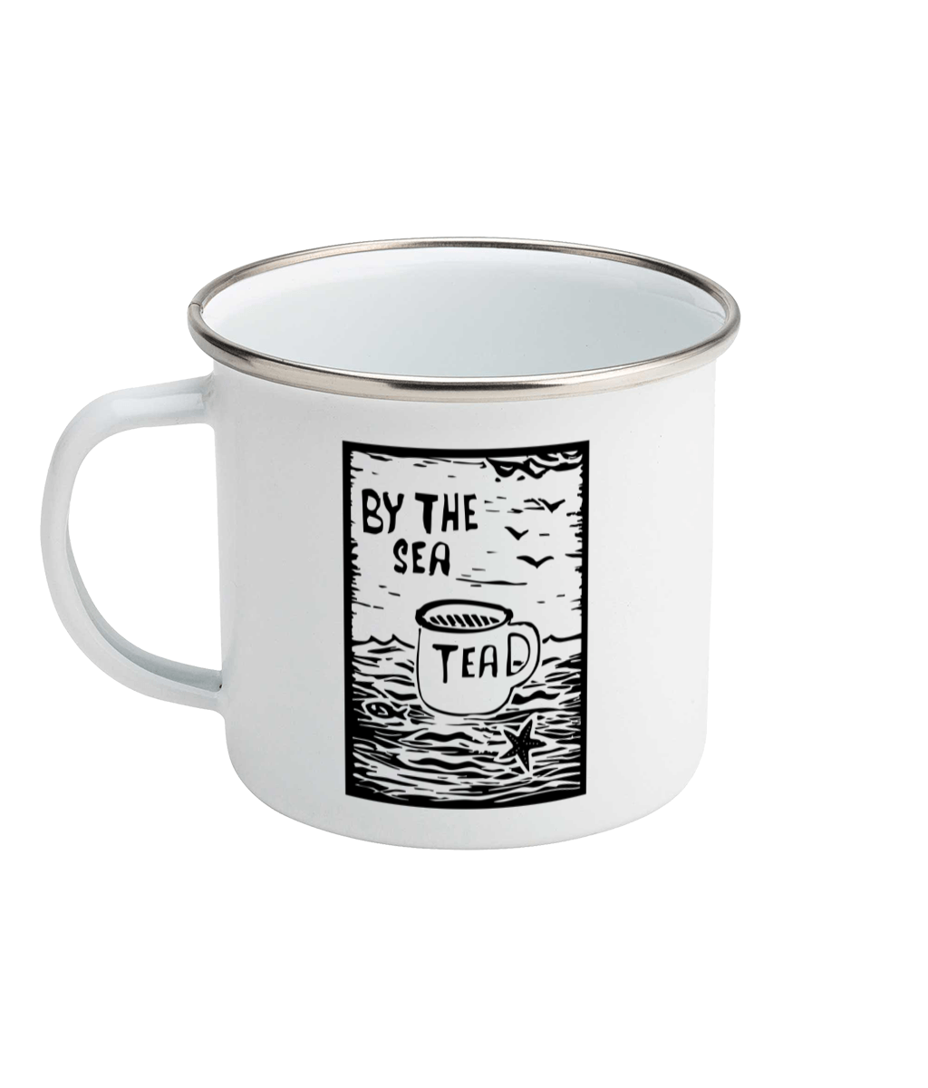 a photograph on a white background of a white enamel mug featuring a Tea By The Sea linocut print design
